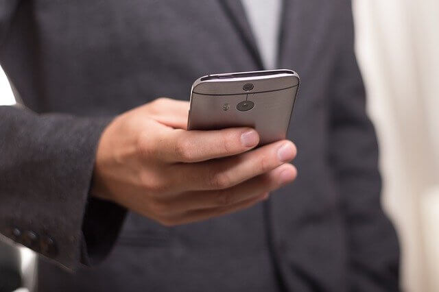 携帯電話を持っている男性の写真