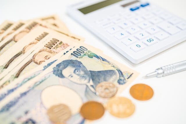 何枚かの千円札と電卓