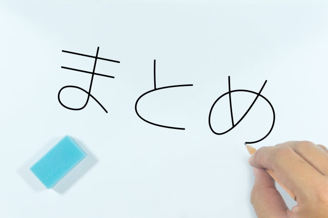 鉛筆で「まとめ」の文字を書いている人の手