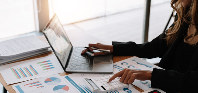 保険代理店システムの概要を示す資料をもとに分析・計算を行うビジネスパーソン