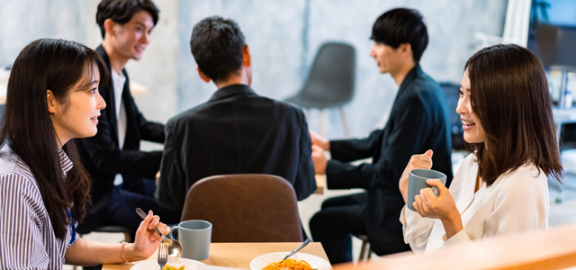 社内の設置型社食スペースでランチを楽しみながら会話する社員たち