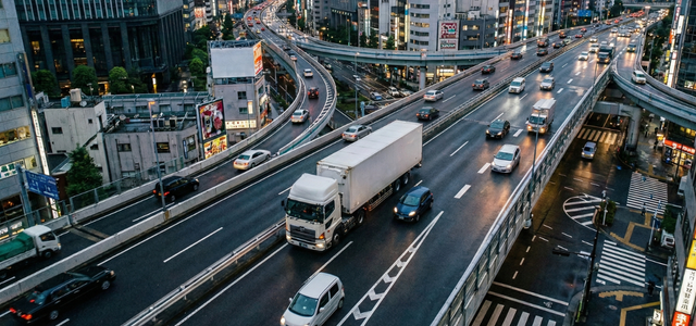 都市高速を走るトラックと車両の交通風景